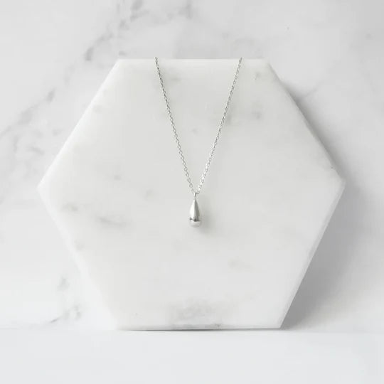以柔和水滴輪廓為靈感設計的極簡風格項鍊，線條流暢、比例俐落，呈現出低調卻耐看的優雅氣質。