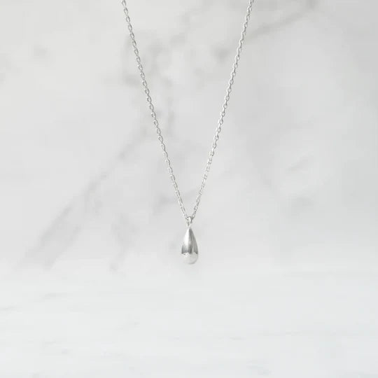 以柔和水滴輪廓為靈感設計的極簡風格項鍊，線條流暢、比例俐落，呈現出低調卻耐看的優雅氣質。