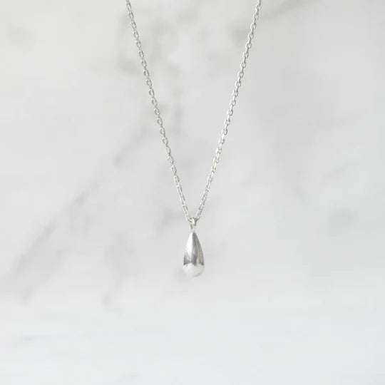 以柔和水滴輪廓為靈感設計的極簡風格項鍊，線條流暢、比例俐落，呈現出低調卻耐看的優雅氣質。