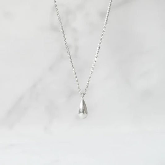 以柔和水滴輪廓為靈感設計的極簡風格項鍊，線條流暢、比例俐落，呈現出低調卻耐看的優雅氣質。