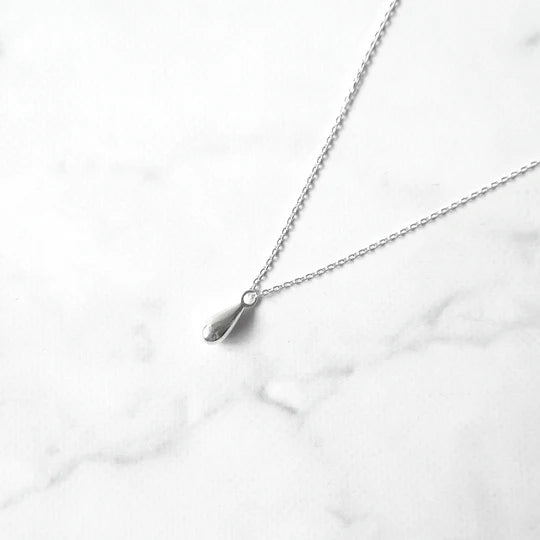 以柔和水滴輪廓為靈感設計的極簡風格項鍊，線條流暢、比例俐落，呈現出低調卻耐看的優雅氣質。