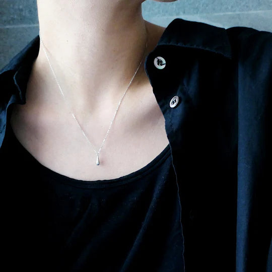 以柔和水滴輪廓為靈感設計的極簡風格項鍊，線條流暢、比例俐落，呈現出低調卻耐看的優雅氣質。