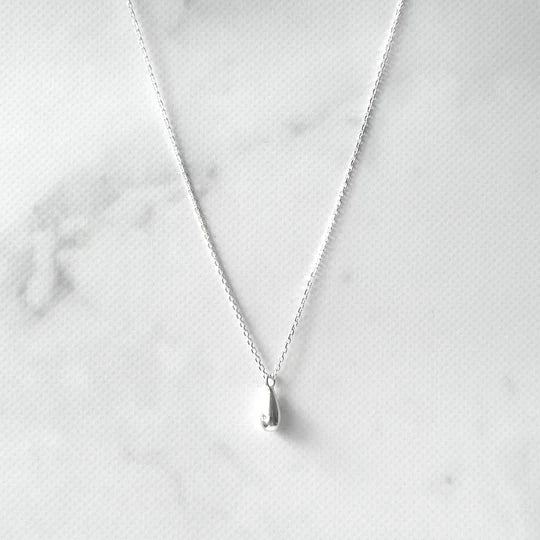 以柔和水滴輪廓為靈感設計的極簡風格項鍊，線條流暢、比例俐落，呈現出低調卻耐看的優雅氣質。