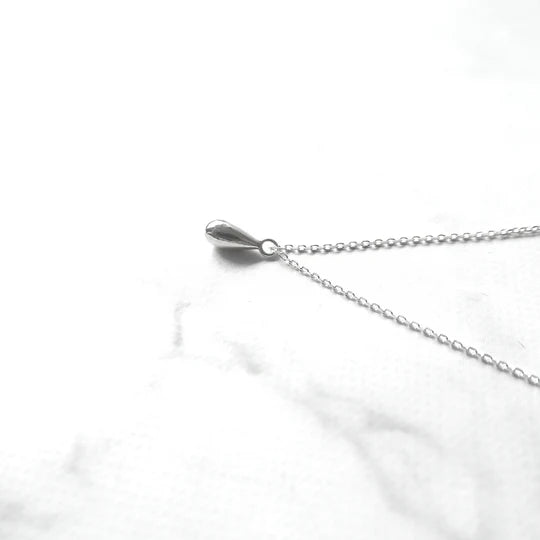 以柔和水滴輪廓為靈感設計的極簡風格項鍊，線條流暢、比例俐落，呈現出低調卻耐看的優雅氣質。